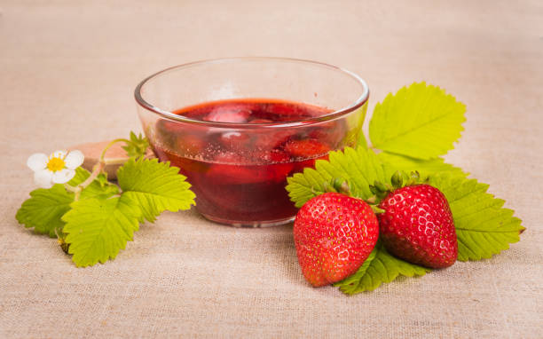 istock Fresh red strawberry and jam on textile background 695048202