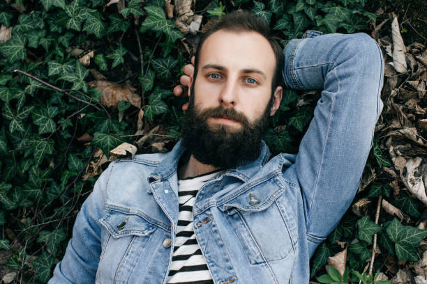 istock bearded man lying on the grass and relaxed 695052386