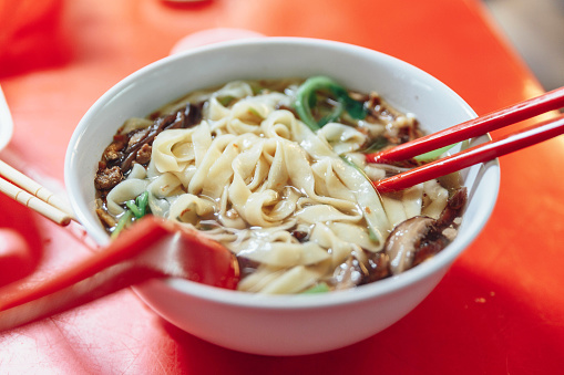 Ban Mian is a popular noodle dish, consisting of handmade noodles with flat egg served in soup or dried with vegetables, anchovy and fish or meat in Kuala Lumpur, Malaysia.