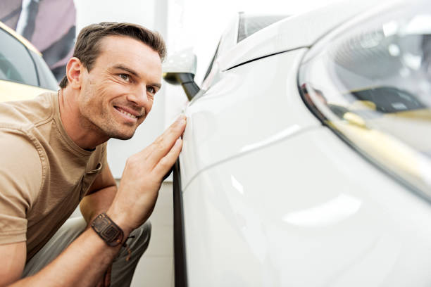 istock Happy male touching wing of automobile 695065886