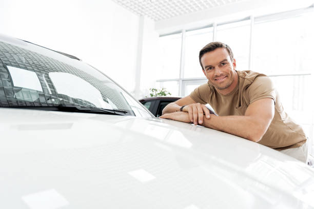 istock Cheerful male reclining on automobile hood 695065964