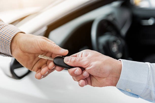 istock Buyer arm taking automobile clef from salesman 695068778