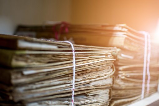 Paper files in a folder is a old documents or old letter it's a age-old and ancient archiving by stacking up in a documents paper shelf messy order
