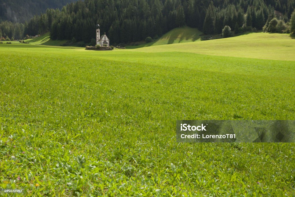 St. Johann little church among a wide green meadow in St. Magdalena , Val di Funes Alto Adige - Italy Stock Photo