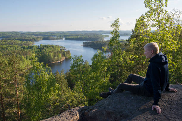Man sitting on high cliff Summer view on Neitvuori national park in Mikkeli region, Finland lappeenranta stock pictures, royalty-free photos & images