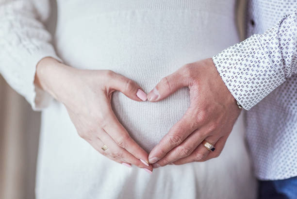 istock couple hands heart on pregnant belly 695072726