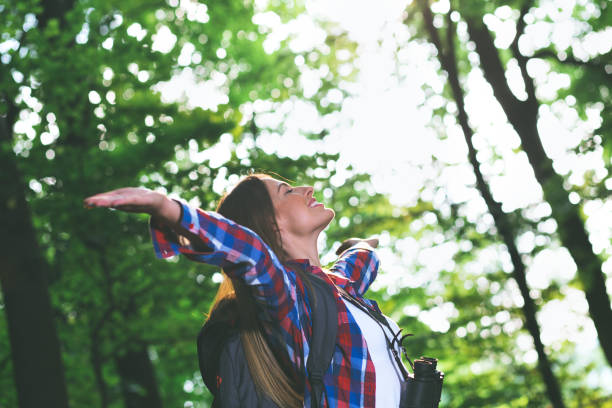 istock Young female hiker with binoculars and backpack in forest. 695088452