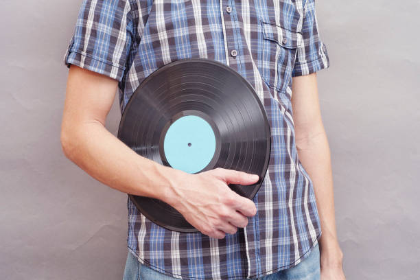 istock Man holds vinyl record in his hand 695090814
