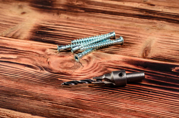 istock Drill bit and confirmats on wooden table 695091480