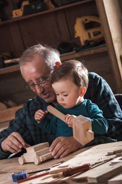 istock Senior carpenter and his grandson having fun in the workshop 695093998