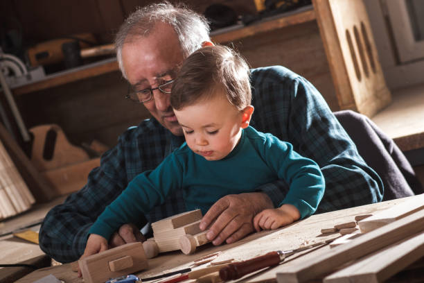 Grandfather teaching grandson woodwork
