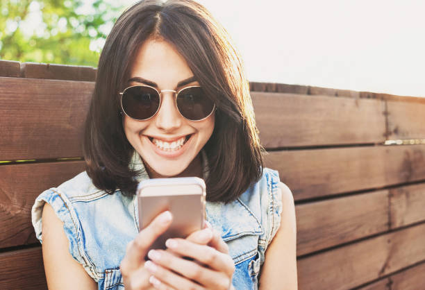 istock Happy trendy girl using smart phone 695097688