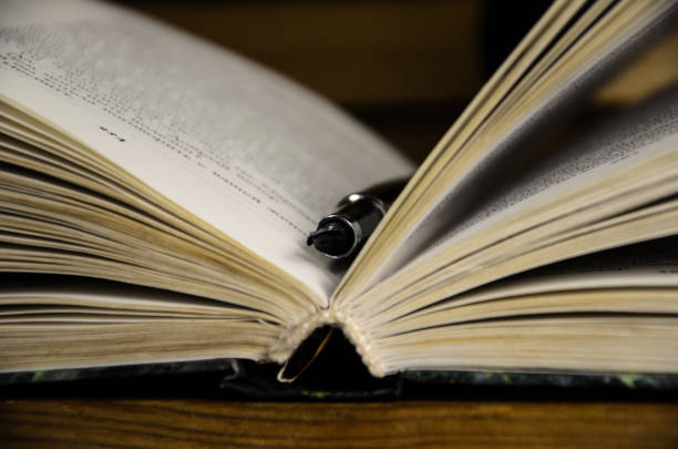 istock Open book and fountain pen 695108380