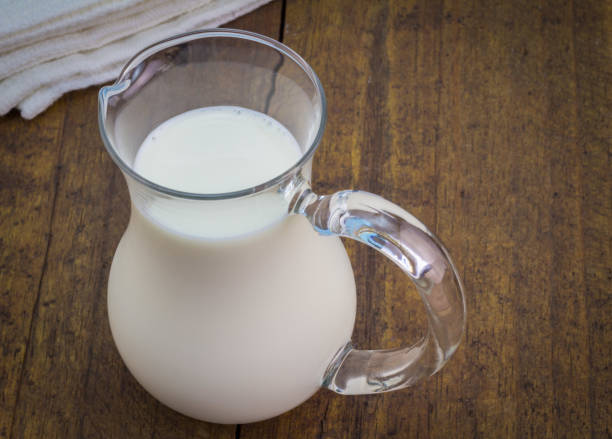 istock Natural whole milk in glass jug on rustic wooden table 695123914