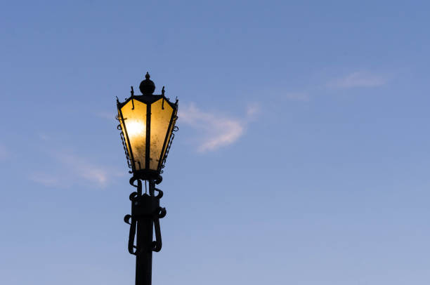 istock Glowing street lamp against a blue sky. 695127114