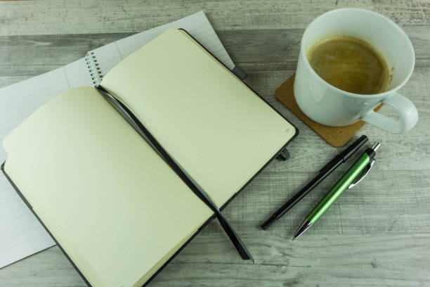 istock Notebook with coffee and ballpoint pen on a desk 695131394