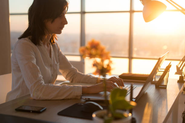 istock Concentrated female employee typing at workplace using computer. Side view portrait of a copywriter working on pc home. 695136746