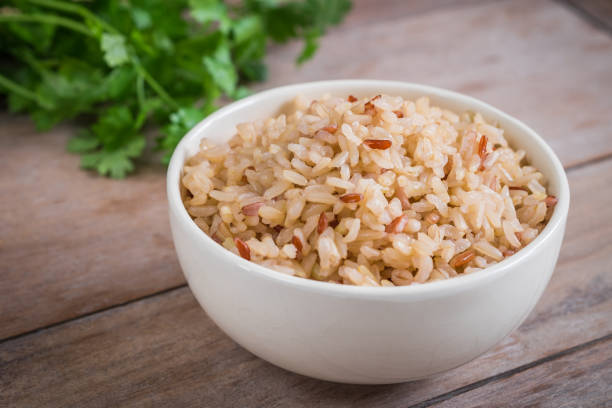 brown rice in bowl - brown rice cooked rice steamed stock-fotos und bilder