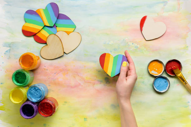 istock Lbgt rainbow hearts in hands top view 695140868