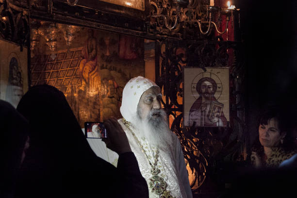 Coptic Patriarch in Holy Sepulchre Jerusalem, Israel - November 10, 2016: Anba Abraham, the Coptic Patriarch of Jerusalem and the Middle East and Coptic pilgrims in a Chapel at the back of the Rotunda in Holy Sepulchre prepare for the consecration during Sunday Holy Mass.  patriarch of jerusalem stock pictures, royalty-free photos & images