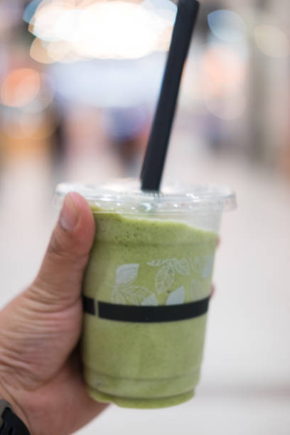 istock Green tea frappe and blended in young hand man 695154956