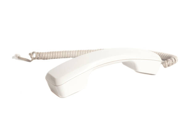 телефонный приемник и шнур изолированы на белом фоне. - telephone telephone receiver phone cord telephone line стоковые фото и изображения