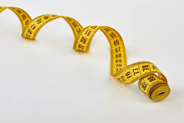 Spirally shape measuring tape. Rolled measuring tape isolated.