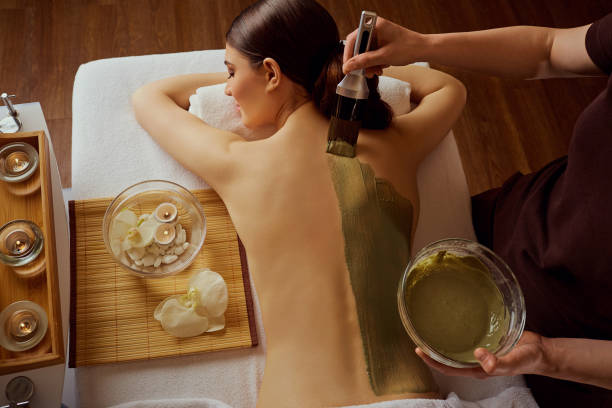 Young woman is put on a mask on her back in  spa salon