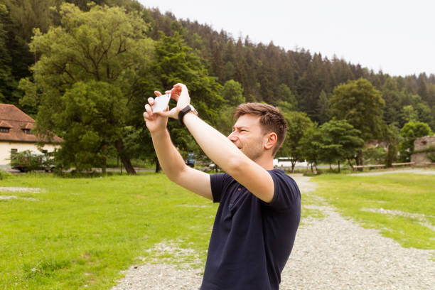 istock Man taking photographs with his smart phone in a field 695177126