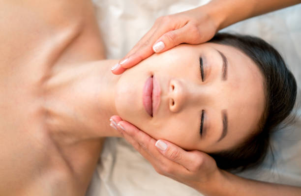 asiatische frau immer eine gesichtsmassage im spa - massaging facial massage human face beautician stock-fotos und bilder