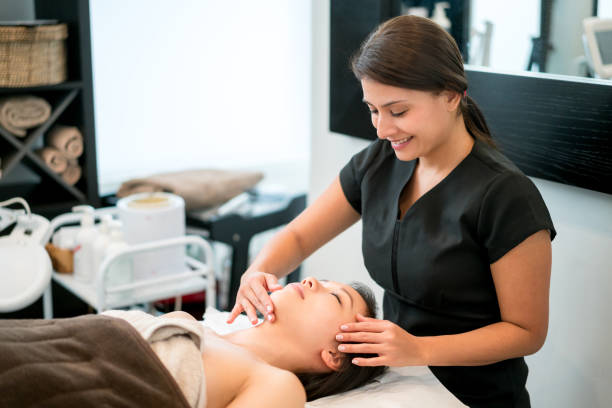 Masseuse giving a facial to a beautiful woman at the spa Portrait of a masseuse giving a facial to a beautiful woman at the spa - beauty treatment concepts beautician stock pictures, royalty-free photos & images