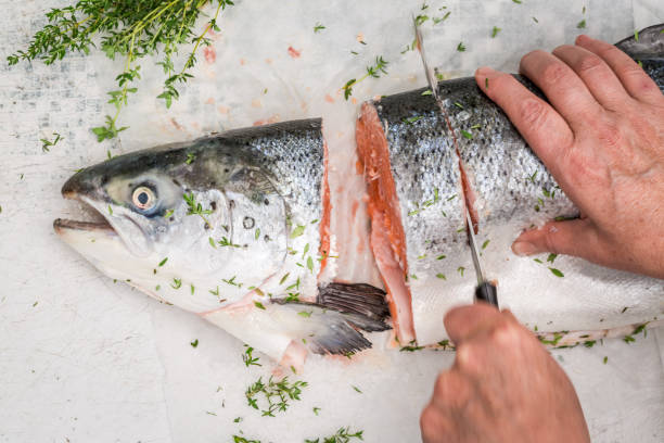 istock Chopping salmon with lemon and herbs for grill 695180286