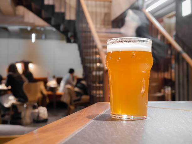 Glass of beer on counter bar in pub background