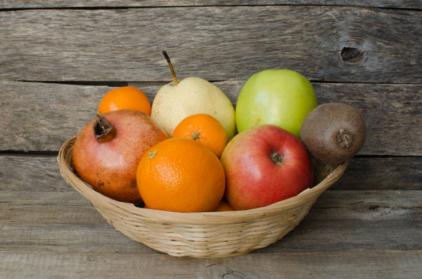 istock Fruits in basket on wooden background 695189578