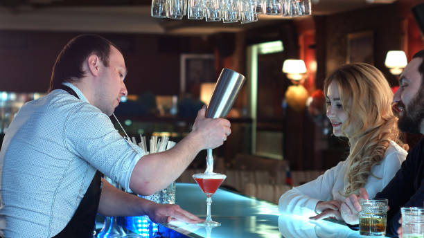istock Bartender preparing cocktail for a girl who is looking forward to sitting at the bar 695199064