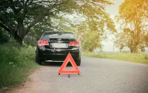 Photo of A car breakdown with Red triangle of a car on the road