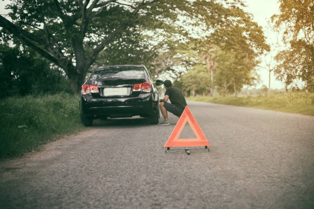 homme stressé assis après une panne de voiture avec triangle rouge d’une voiture sur la route - service land vehicle warning sign road photos et images de collection