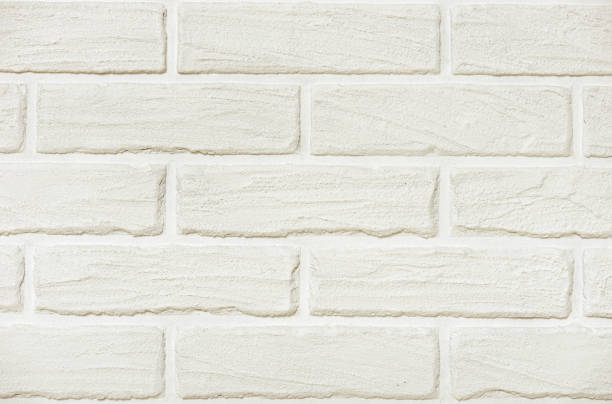 istock white brick wall background photo, yellow toned 695214876