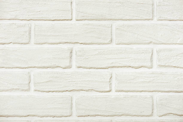 istock white brick wall background photo, yellow toned 695215176
