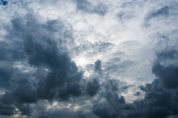 istock clouds with background,sunlight through very dark clouds background of dark storm clouds,black sky Background of dark clouds before a thunder. 695215618