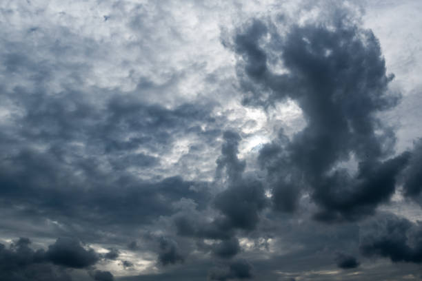 istock clouds with background,sunlight through very dark clouds background of dark storm clouds,black sky Background of dark clouds before a thunder. 695216002