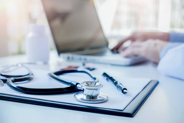 Stethoscope with clipboard and Laptop on desk Doctor working in hospital writing a prescription Healthcare and medical concept test results in background vintage color selective focus. estetoscopio con portapapeles y portátil en el escritorio del doctor trabajando en el hospital un resultados de prueba de concepto profesional de la salud y médicos de prescripción de la escritura en enfoque selectivo del color de la vendimia de fondo.
