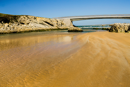 Beach under a bridge with clear sand