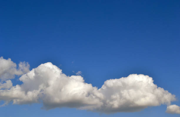 Fluffy clouds in a clear sky stock photo