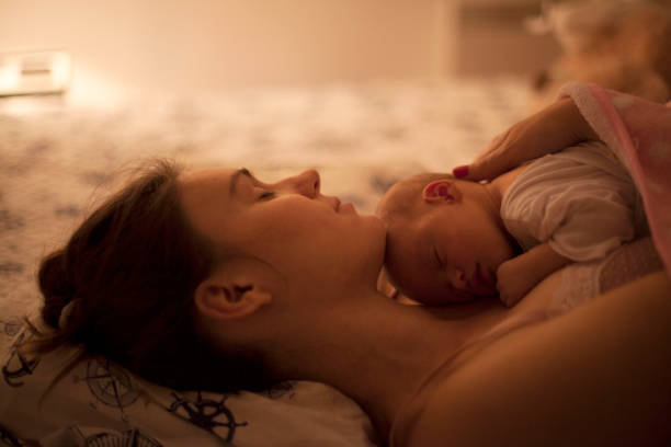 istock Sleeping newborn baby in mother embrace 695255572