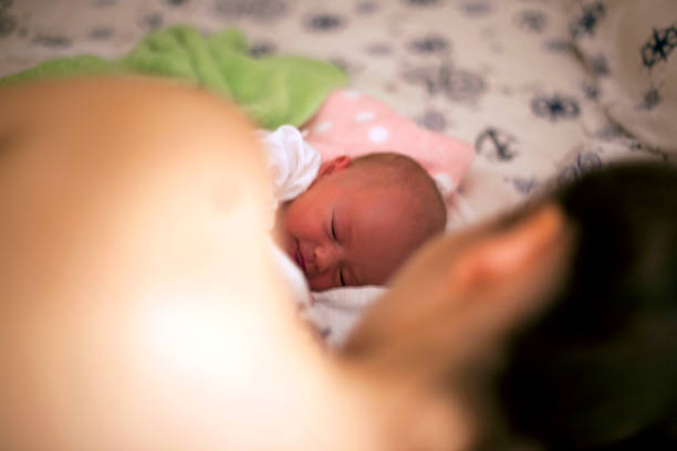 istock Sleeping newborn baby in mother embrace 695255574