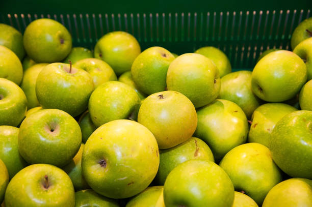 Bunch of red and green apples on boxes in supermarket