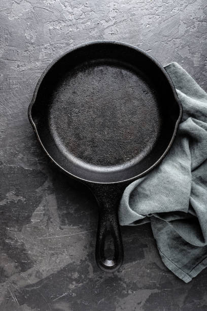 istock Empty cast iron frying pan on dark grey culinary background, view from above 695264768