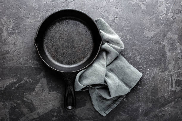 istock Empty cast iron frying pan on dark grey culinary background, view from above 695264814