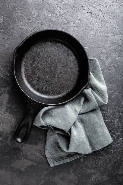 istock Empty cast iron frying pan on dark grey culinary background, view from above 695264828